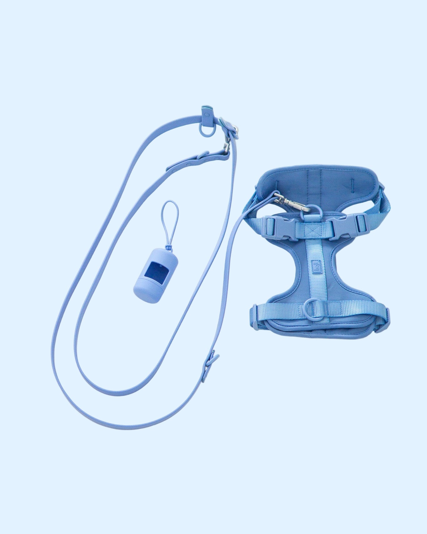 Blue dog harness, leash, and whistle set on a white background